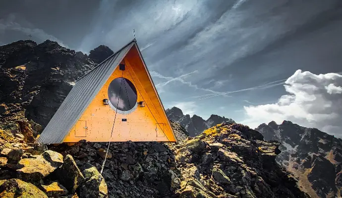 Moderne Schutzhütte mit spitzem Dach und rundem Fenster in  den Alpen über Pfunds